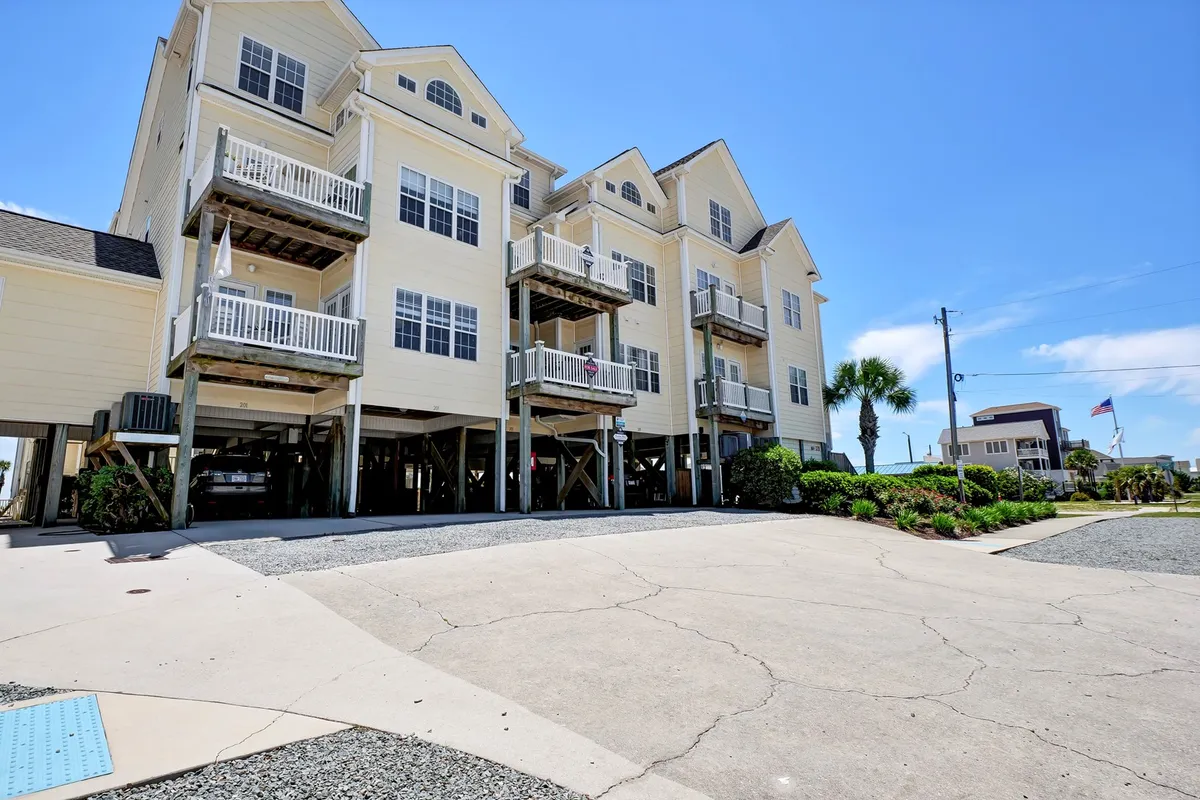 A cheerful exterior view of the multi-story Summer Winds building, with inviting balconies and lush palm trees setting a relaxed, coastal vacation mood. The image hints at the proximity to local attractions and the possibility of relaxing on private balconies.